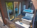 The patio offers cozy seating and a private hot tub.
